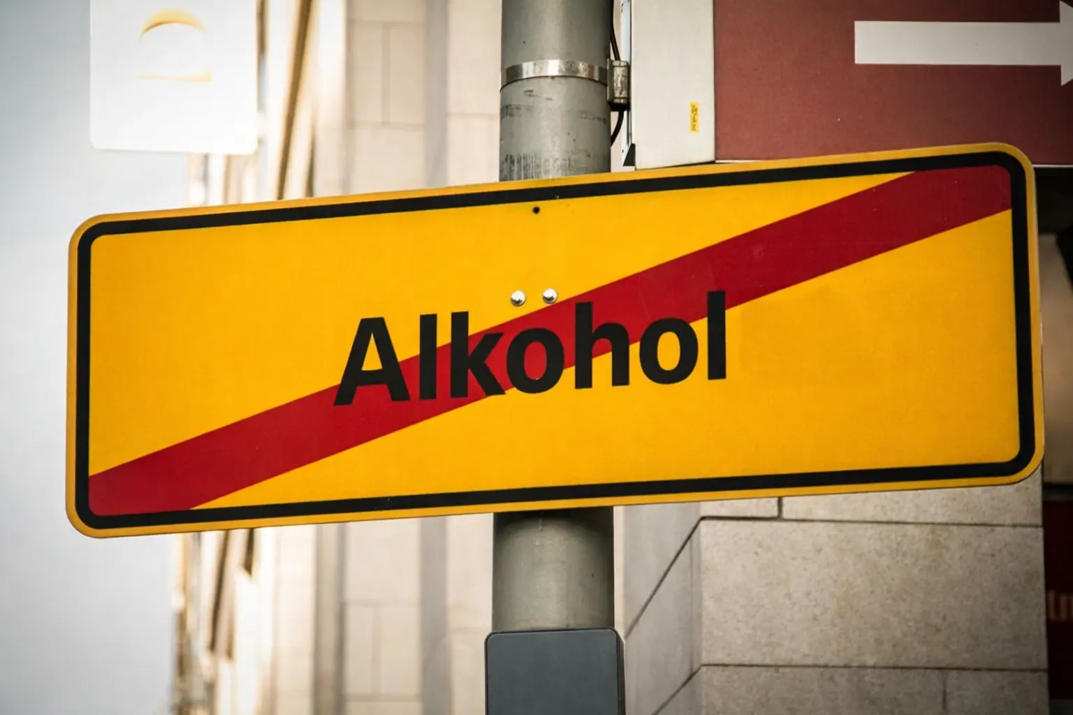 Yellow road sign with the word Alkohol crossed out, symbolizing the decision to maintain a strictly alcohol-free home environment during early recovery.