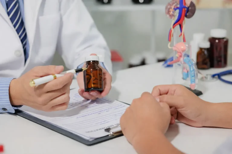 Doctor holding a medication bottle while discussing treatment with a patient in a clinical office setting.