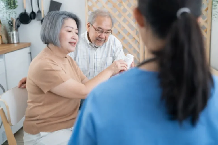An older couple participates in a medical history review with a healthcare staff member during the admissions process for a treatment program.