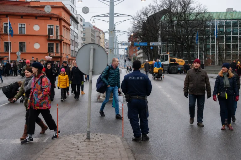 Suomalainen poliisi seisoo kadulla väkijoukon keskellä talvisessa kaupungissa