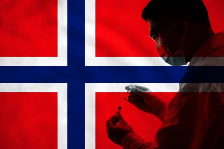 Medisinsk personale forbereder sprøyte foran norsk flagg