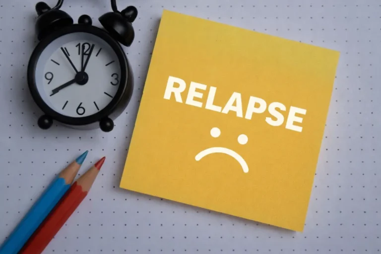Yellow sticky note with the word Relapse and a sad face next to an alarm clock, symbolizing the time-sensitive nature of addiction recovery and intervention.
