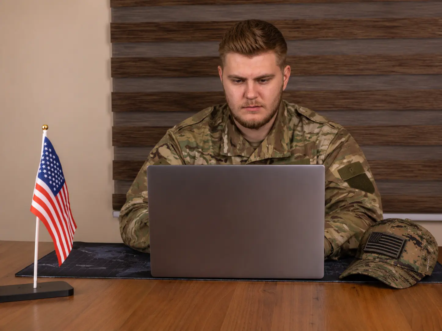 U.S. veteran in military uniform reviewing VA Foreign Medical Program coverage options on a laptop