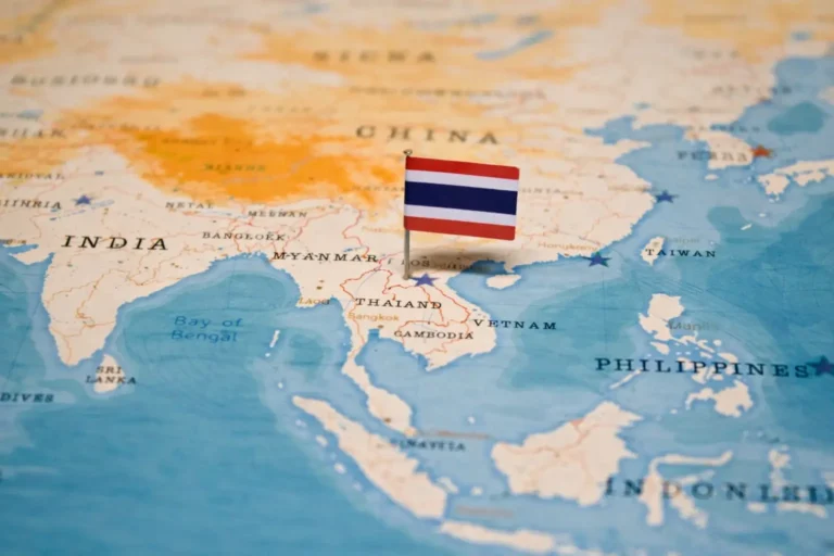 Close-up of a map of Asia with a pin bearing the Thailand flag marking the country's location.